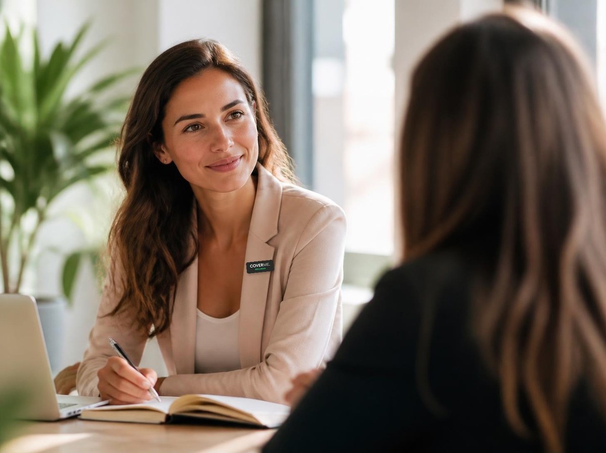 A CoverMe Wellness account manager in smart casual clothes listening attentively to a client and taking notes